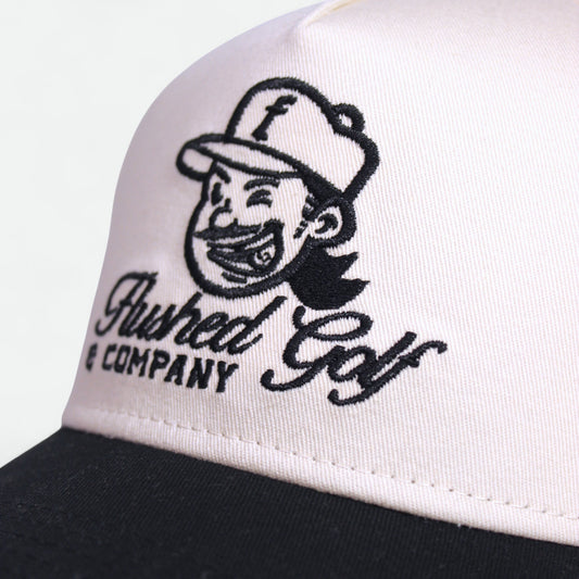 Close-up of embroidered Flushed Golf logo on Classic golf hat with black brim