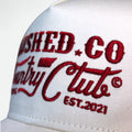 Close-up of Country Club graphic on red Flushed Golf trucker hat