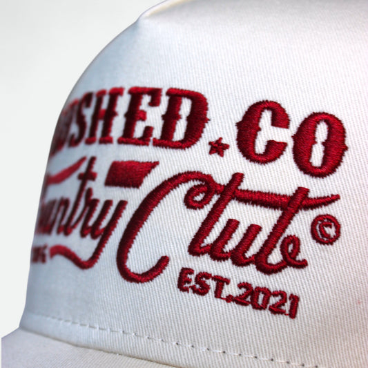 Close-up of Country Club graphic on red Flushed Golf trucker hat