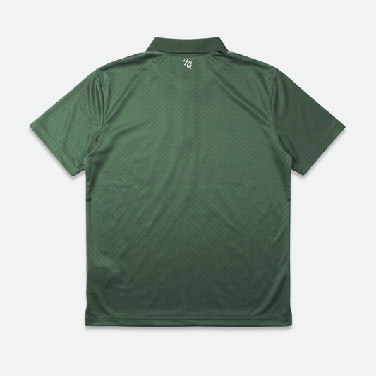 Green golf polo shirt with a cleef patterned design on a light gray background