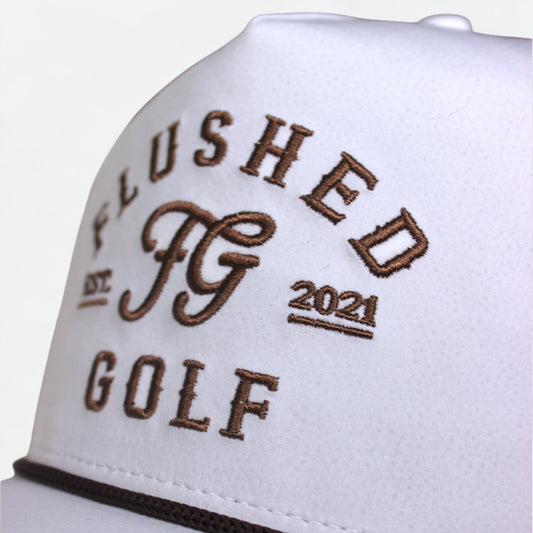 Close-up of embroidered logo and rope detail on brown Flushed Golf rope hat